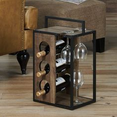 a wine rack with bottles and glasses in it sitting on a wooden floor next to a couch