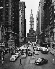 an old black and white photo of cars on a city street