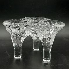 three clear glass vases sitting on top of a black table next to each other