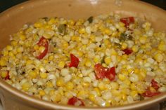 a bowl filled with corn and red peppers