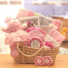 a basket filled with baby items on top of a white table next to a pink teddy bear