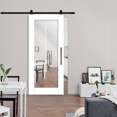 a living room filled with furniture and a white door leading to a dining room area