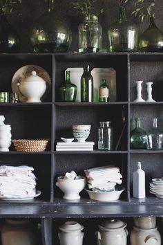 a shelf filled with lots of vases and dishes