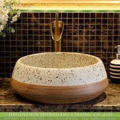 a bathroom sink sitting on top of a counter next to a vase with flowers in it