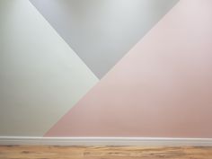 an empty room with pink and grey walls