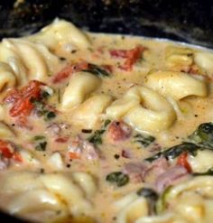 pasta with spinach and tomato sauce in a skillet