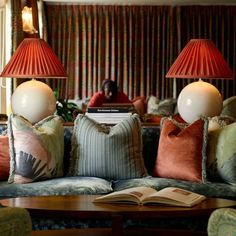 a living room filled with furniture and two red lamps on top of each other's head