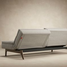 a couch that is sitting on top of a wooden frame and has two back cushions