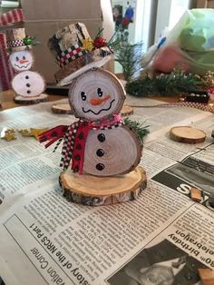 a snowman made out of wood sitting on top of a newspaper