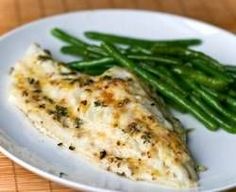 a white plate topped with fish and green beans