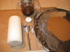 a metal pan sitting on top of a wooden table next to a bottle and spoon