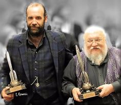 two men are holding trophies in their hands