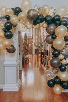 an arch made out of balloons and streamers on the floor in front of a doorway