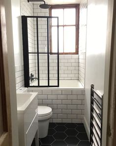 a white toilet sitting next to a window in a bathroom