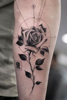 a black and white rose tattoo on the right thigh, with geometric shapes around it