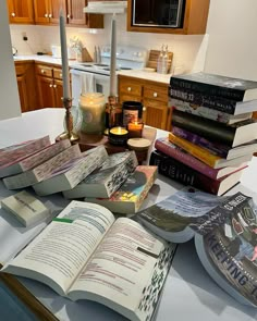 a table topped with lots of books and candles