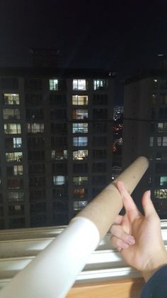 a person holding up a long piece of paper in front of a cityscape