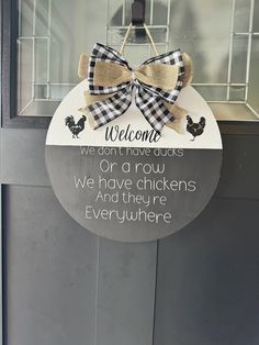 a welcome sign hanging from the side of a glass door with a bow on it