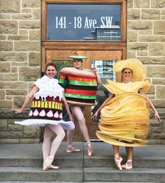 three people dressed in costumes standing on steps