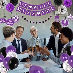 a group of people sitting around a table with balloons and confetti