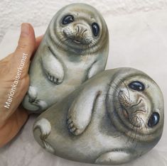 two small sea lions sitting next to each other on top of a white tablecloth