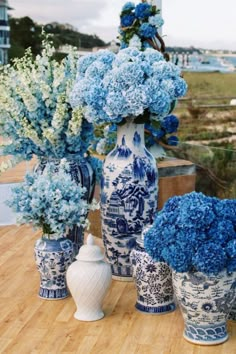 blue and white vases with flowers in them on a table