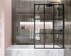 a bathroom with pink walls and marble flooring is pictured in this image, the shower area has an open glass door