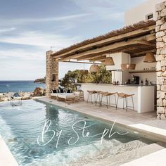 an outdoor bar next to a swimming pool with chairs and tables on the patio overlooking the ocean