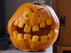 a pumpkin carved to look like a face with teeth on it's front and side