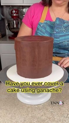 a woman in an apron is cutting a chocolate cake with the words have you ever cover a cake using ganache?