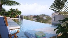 an outdoor pool with lounge chairs and towels on the ground next to it, surrounded by palm trees