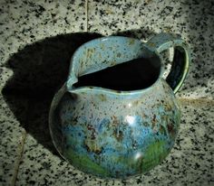 a blue and green vase sitting on top of a counter