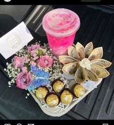 flowers and chocolates are sitting on the back seat of a car next to a pink drink