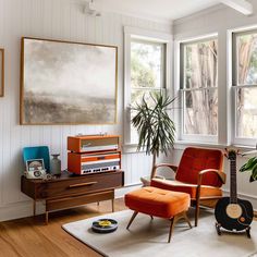 a living room filled with furniture and a guitar on the floor next to a window