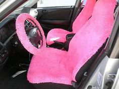 the interior of a car is covered in pink fuzzy fabric and has a steering wheel cover