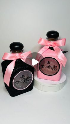 two small bottles with pink bows on them