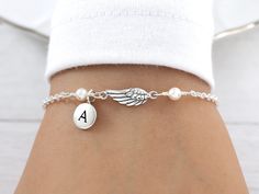 Personalized Angel Wing Bracelet.  This beautiful Angel Wing Bracelet features a dainty Sterling Silver Angel Wing accented with a sterling silver initial charm and two Pearl colors or Birthstone crystals of your choice on a sterling silver cable chain finished with a lobster clasp closure.  Bracelet is solid sterling silver, fully adjustable and comes with the option to add a complimentary, custom printed gift note (see last pictures for examples). ADD ANOTHER INITIAL:  https://www.etsy.com/lis Swarovski Pearls Bracelet, Angel Wing Bracelet, Angel Bracelet, Silver Initial Charms, Silver Angel Wings, Angel Jewelry, Sterling Silver Initial, Chain Extenders, Swarovski Pearls