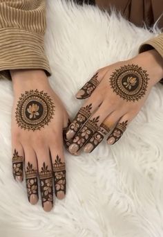 two hands with henna tattoos on them