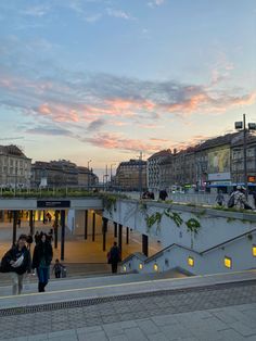 people are walking up and down the stairs in an urban area at sunset or dawn