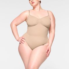 The internet’s favorite sculpting bodysuit, updated for an even better fit. This waist-cinching style enhances your shape with extra compression at the core and waist and has perfectly-placed style lines that flatter your bust. Features adjustable straps, a wide crotch for added coverage, and a cotton gusset with snap closure. Fits true to size. | SKIMS Thong Bodysuit | Light Neutral | Seamless Sculpt Cinched Waist, Polished Look, Shapewear, Luxury Fabrics, Suits You, Kim Kardashian, Breathable Fabric, Lounge Wear, V Neck