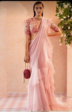 Gossamer pink hue plain frill saree with V- neckline embellished blouse can be a good opt for those who are looking for subtle yet fashionable look. It's good for daylight wedding function. Padma Priya, Ridhi Mehra, Draped Saree, Outfits Indian, Ring Ceremony, Ruffle Saree, Drape Saree