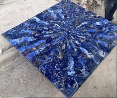 a square blue marble table top sitting on the side of a road with words stonecraftial gallery above it