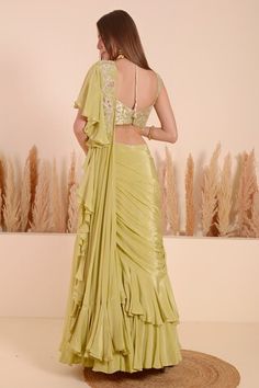 Green lehenga saree with ruffled pallu and hand embroidered moti blossom detailing. Paired with a sleeveless brocade bloom jaal detail blouse using moti, sequins, beads highlights. - Aza Fashions Fitted Pista Green Blouse Piece For Wedding, Fitted Pista Green Blouse For Reception, Pista Green Art Silk Saree Dress, Fitted Pista Green Pre-draped Saree For Eid, Fitted Traditional Wear With Ruffles, Diwali Dress With Unstitched Blouse In Pista Green, Pista Green Pre-draped Saree With Dori Work For Wedding, Diwali Pista Green Dress With Unstitched Blouse, Fitted Gown With Dori Work And Traditional Drape