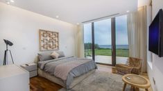 a bedroom with a large bed and a flat screen tv mounted on the wall above it