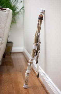 an umbrella is leaning against the wall in front of a couch and potted plant