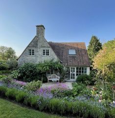 a house with lots of flowers in front of it