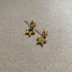 Dangle star earrings. Water-resistant and tarnish-free.  100% stainless steel. Modern Gold Star Earrings, Modern Gold Star-shaped Earrings, Star Shaped Nickel Free Plug Earrings For Gift, Nickel-free Star Shaped Plug Earrings For Gift, Star-shaped Nickel-free Plug Earrings As Gift, Star-shaped Nickel-free Plug Earrings For Gift, Minimalist Star Charm Earrings As Gift, Star-shaped Tarnish Resistant Earrings For Gift, Minimalist Star-shaped Tarnish Resistant Earrings