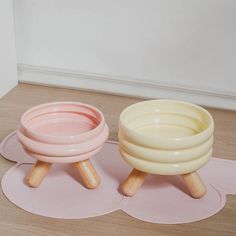 two bowls sitting on top of each other in front of a white and pink wall