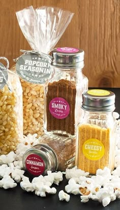 three bags of popcorn sitting on top of a table next to some other food items