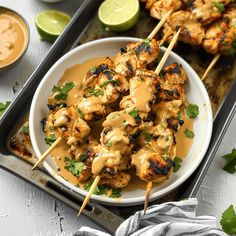 chicken skewers covered in sauce and garnished with cilantro